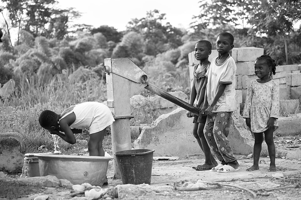Children collecting water at a pipe well in Ghana